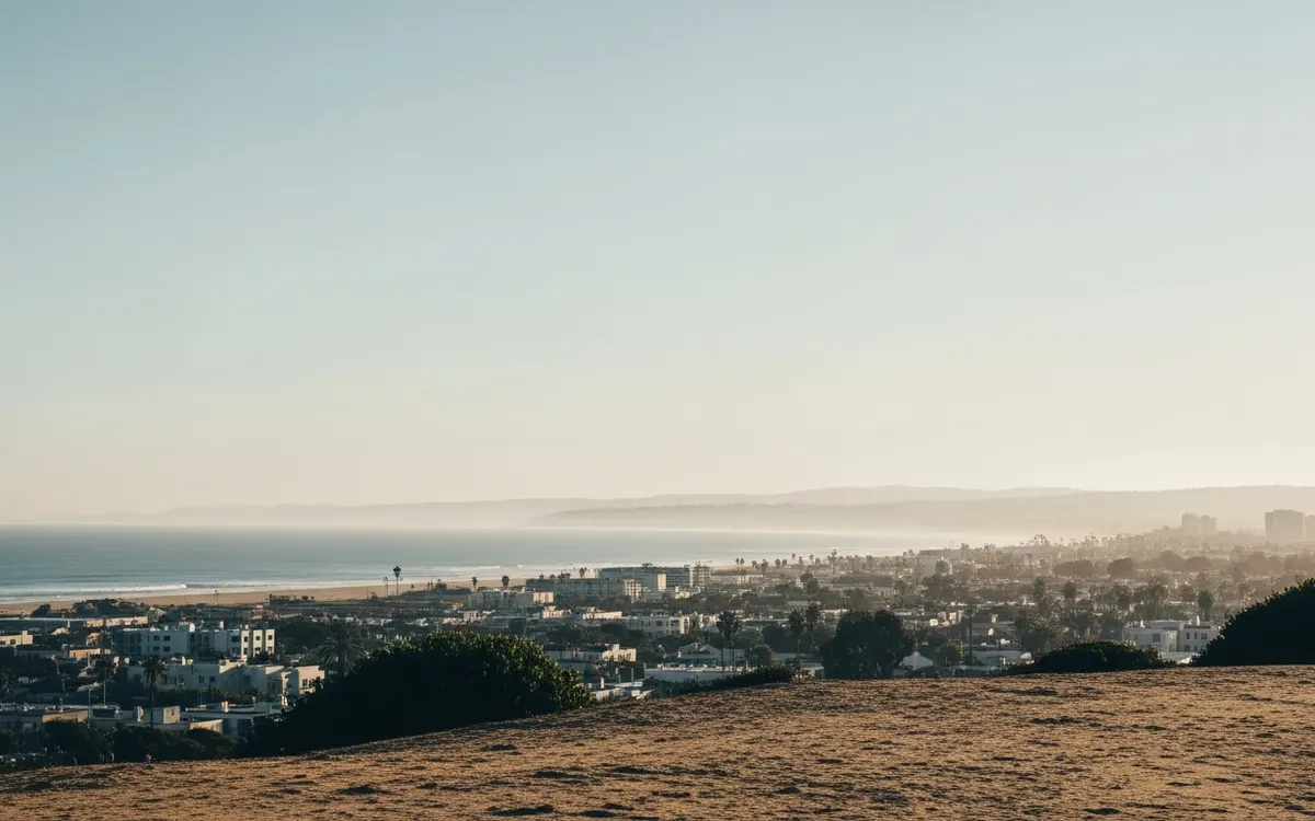 Calm Southern California cityscape and open sky over a low coastal-plain horizon in soft morning light