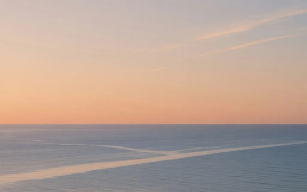 Soft morning light moving across a calm coastal horizon